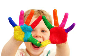 Five year old boy with hands painted in colourful paints ready for hand prints (istockphoto.com)